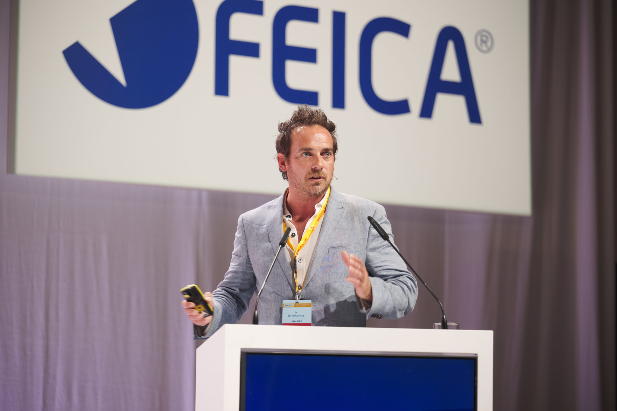 Ian Spreadborough IOBAC - presenting on stage at a flooring conference